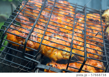 The chicken is grilled on fire. Close-up. Weekend The chicken is grilled on fire. Close-up. Weekend 57668738