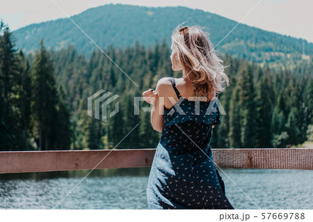 Smiling woman against mountain landscape and lake 57669788