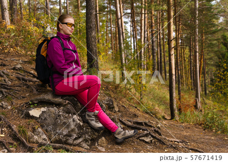 woman traveler sat down to rest on a stone woman traveler sat down to rest on a stone 57671419