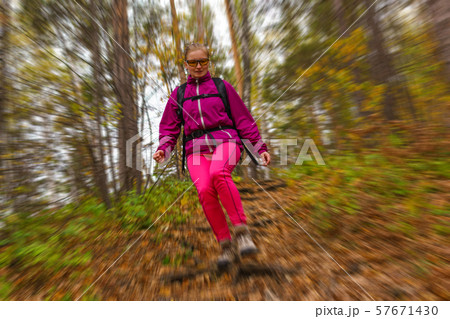 woman traveler descends from a hill in the autumn 57671430