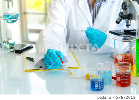 Young female doing experiments and researchers Young female doing experiments and researchers 57672018