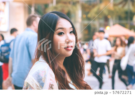 Beautiful Asian woman smiling with outdoor scene. 57672271