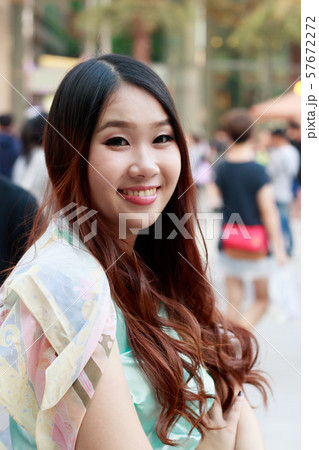 Beautiful Asian woman smiling with outdoor scene. 57672272