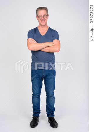 Full body shot of happy mature man smiling with arms crossed against white background 57672273
