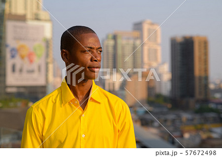 Young thoughtful bald African businessman against view of the city 57672498