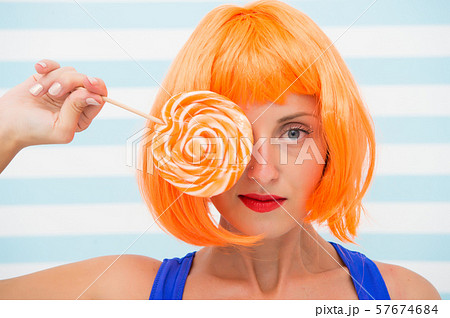 cosplay girl with crazy look hold orange lollipop. cosplay girl with crazy look hold orange lollipop. 57674684