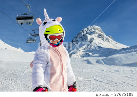 Cute adorable preschooler caucasian kid girl portrait with ski in helmet, goggles and unicorn fun 57675189
