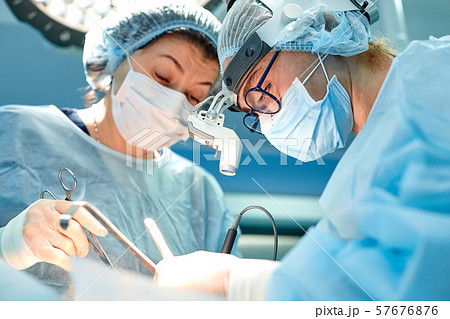 Portrait of team of multiethnic surgeons at work in a operation theatre. Several doctors surrounding 57676876