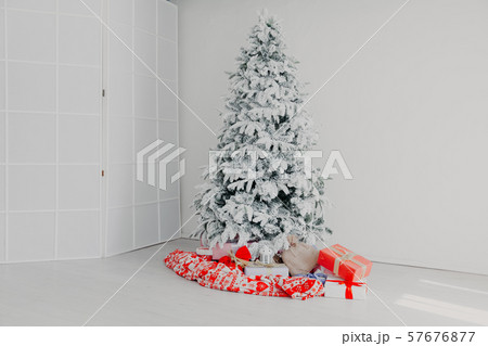 Christmas tree in a white room with gifts in the winter 57676877