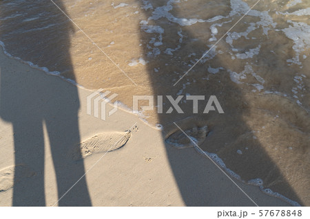 砂浜に写る恋人たちの影 57678848