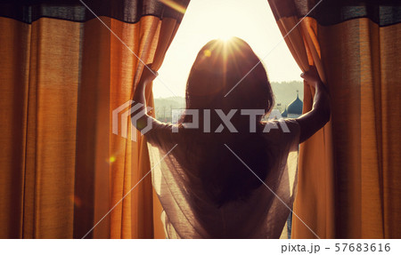 young woman stand in the room open curtain see 57683616