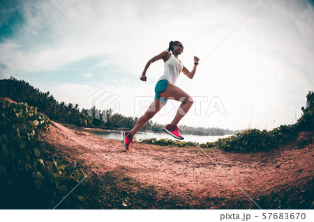Woman trail runner running on seaside hills 57683670