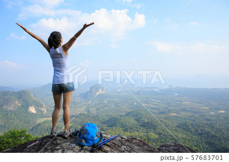 Successful woman hiker open arms at mountain top Successful woman hiker open arms at mountain top 57683701