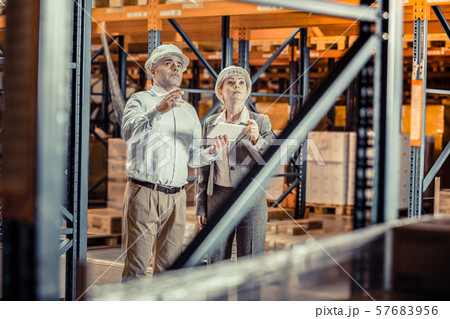 Attentive partners looking upwards at metal construction Attentive partners looking upwards at metal construction 57683956