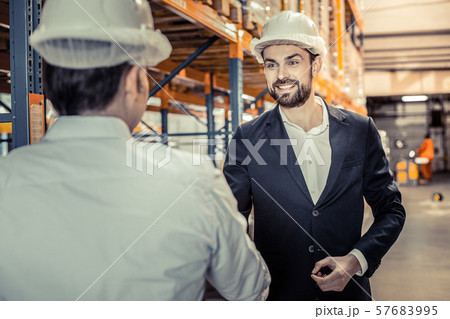 Joyful young manager talking to his employee Joyful young manager talking to his employee 57683995
