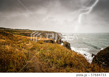 Lightning bolt strike from a thunderstorm near the sea Lightning bolt strike from a thunderstorm near the sea 57684733