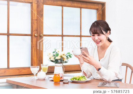 ビジネスウーマン 朝食 スマホ ビジネスウーマン 朝食 スマホ 57685725
