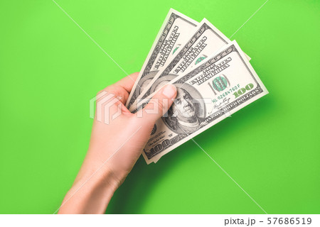 Dollars in woman hand on green background. Dollars in woman hand on green background. 57686519
