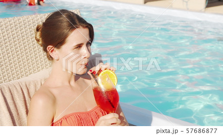 Beautiful happy woman enjoying drinking cocktail at the poolside 57686877