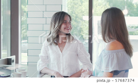 Beautiful woman meeting her female friends at the coffee shop Beautiful woman meeting her female friends at the coffee shop 57687374