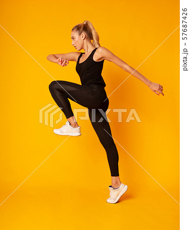 Fitness Girl Jumping During Cardio Workout, Studio Shot Fitness Girl Jumping During Cardio Workout, Studio Shot 57687426