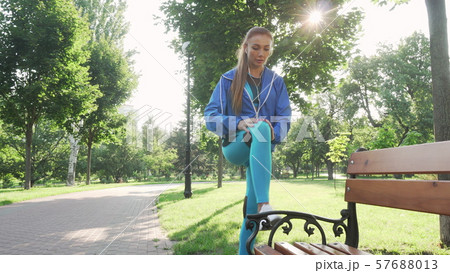 Attractive sportswoman stretching outdoors in the park Attractive sportswoman stretching outdoors in the park 57688013