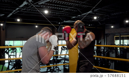 Two male boxers sparring in boxing ring at the gym Two male boxers sparring in boxing ring at the gym 57688151