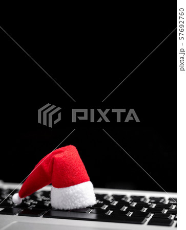 Santa Claus Hat on laptop keyboard. Searching 57692760