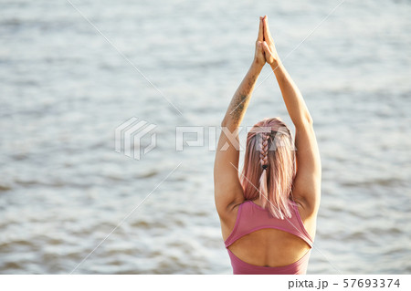 Woman doing yoga near the sea 57693374