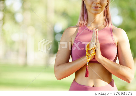 Woman practising yoga outdoors Woman practising yoga outdoors 57693575