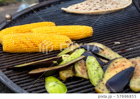 A cook fries corn and vegetables on a charcoal 57696855