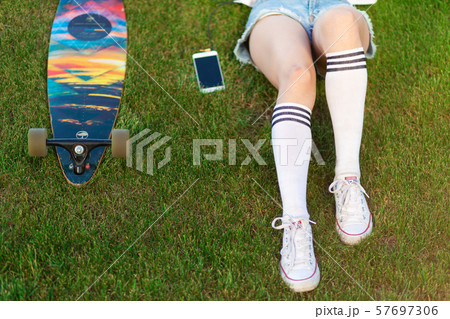 Young girl enjoy lay in green lawn and listening 57697306
