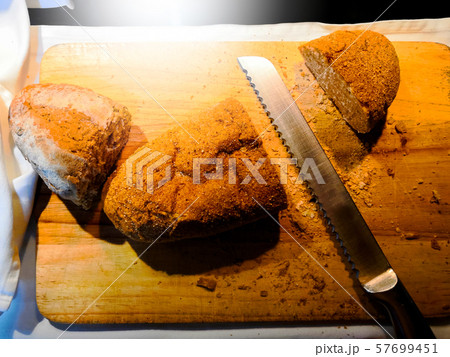 Whole grain bread on cutting board with knife Whole grain bread on cutting board with knife 57699451