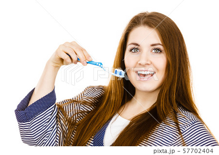 Woman holds toothbrush with paste. Woman holds toothbrush with paste. 57702404