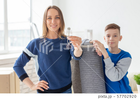 Blurry good looking mom and son are holding the keys to a new apartment after the housewarming. New Blurry good looking mom and son are holding the keys to a new apartment after the housewarming. New 57702920