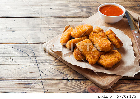 chicken nuggets with tomato sauce on wooden background. Copy space. chicken nuggets with tomato sauce on wooden background. Copy space. 57703175