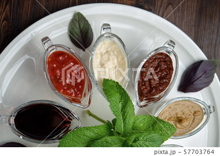 sauces in bowls on a dark wooden background. menu for catering sauces in bowls on a dark wooden background. menu for catering 57703764