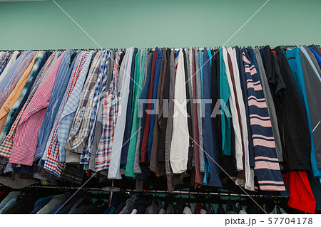 Colorful clothes on hangers in a store. 57704178