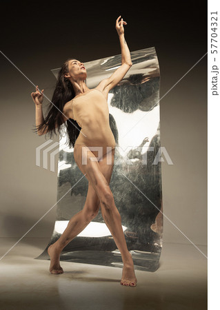 Young and stylish modern ballet dancer on brown background 57704321