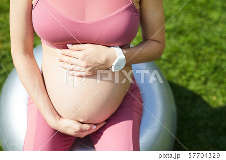 Pregnant woman doing fitness exercises 57704329
