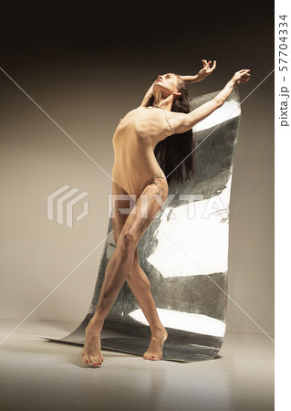 Young and stylish modern ballet dancer on brown background 57704334