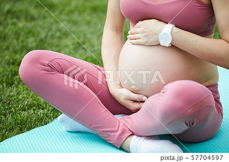 Pregnant woman exercising in the park Pregnant woman exercising in the park 57704597