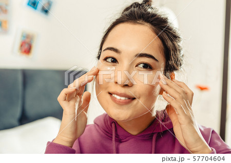 Young woman moistening her skin in the morning 57704604