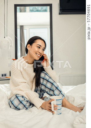 Cheerful girl talking to her friend by phone 57704691