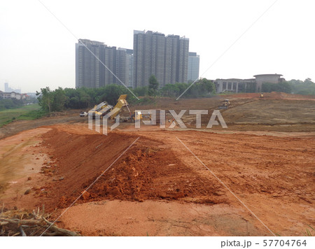 Heavy machinery doing the earthwork and site clearing at the construction site. 57704764