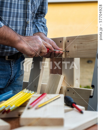 Craftsman at work on wooden boards. 57704928