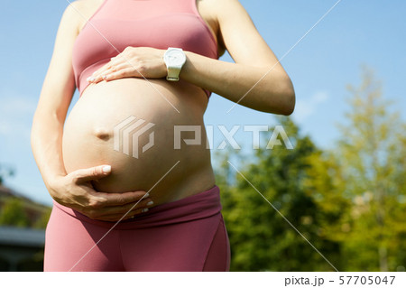 Pregnant woman walking outdoors Pregnant woman walking outdoors 57705047