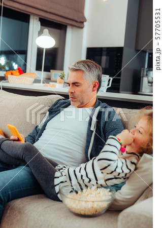 Serious grey-haired male person staring at his gadget Serious grey-haired male person staring at his gadget 57705531