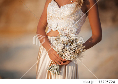 Portrait of beautiful bride is wearing fashion flying dress and wreath in the great desert in Dubai. 57705728