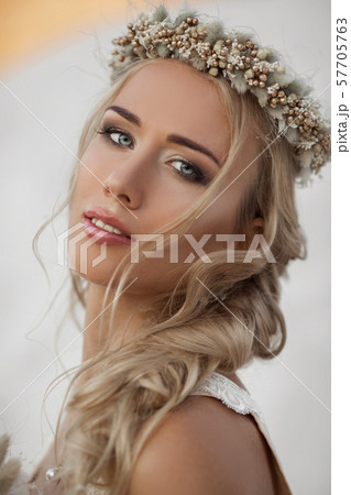 Portrait of beautiful bride is wearing fashion flying dress and wreath in the great desert in Dubai. 57705763
